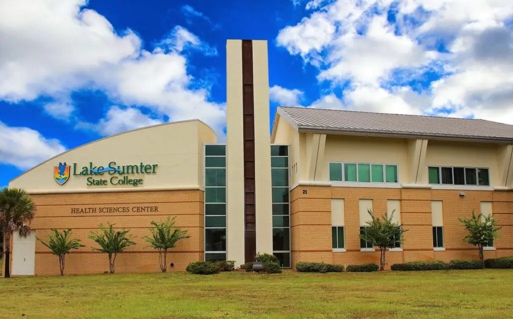 Exterior view of Lake Sumter State College building with modern architecture, featuring large glass windows and a landscaped
