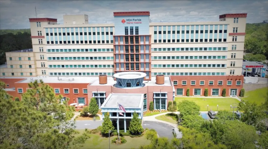Capital Regional Medical Center building with modern architecture, large windows, and surrounding greenery on a sunny day.