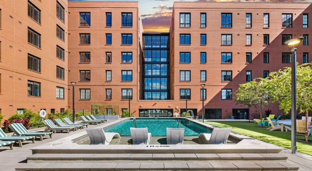 Modern loft interior with large windows, exposed brick walls, and contemporary furnishings in a stylish urban setting.